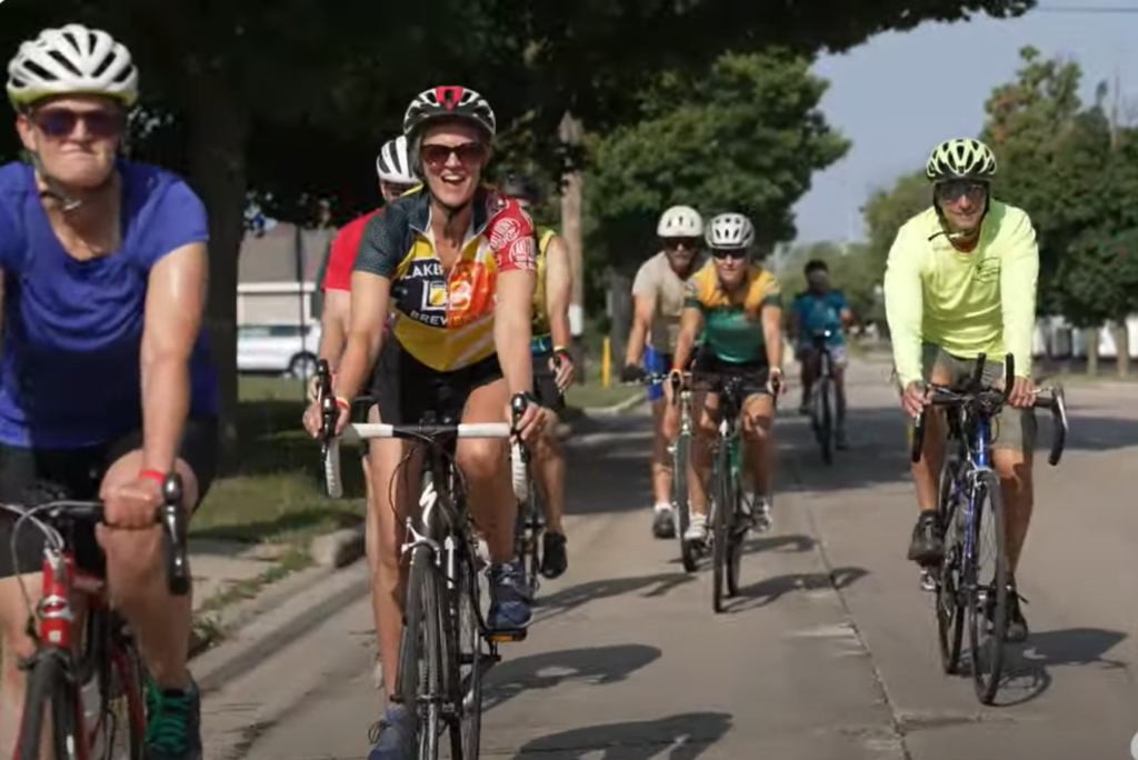 Cyclists participating in Bike To The Beat 2023, riding through scenic Wisconsin landscapes with live music energizing the atmosphere.