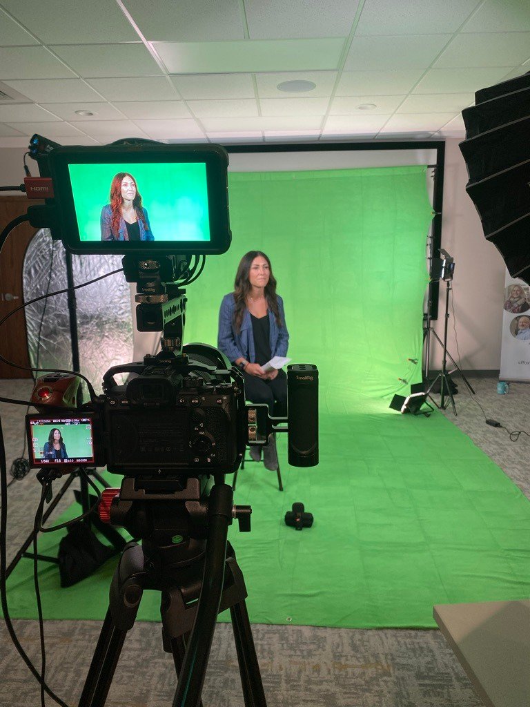 A videographer capturing an interview with an AFP Award Winner using a green screen setup, professional lighting, and high-quality cameras.